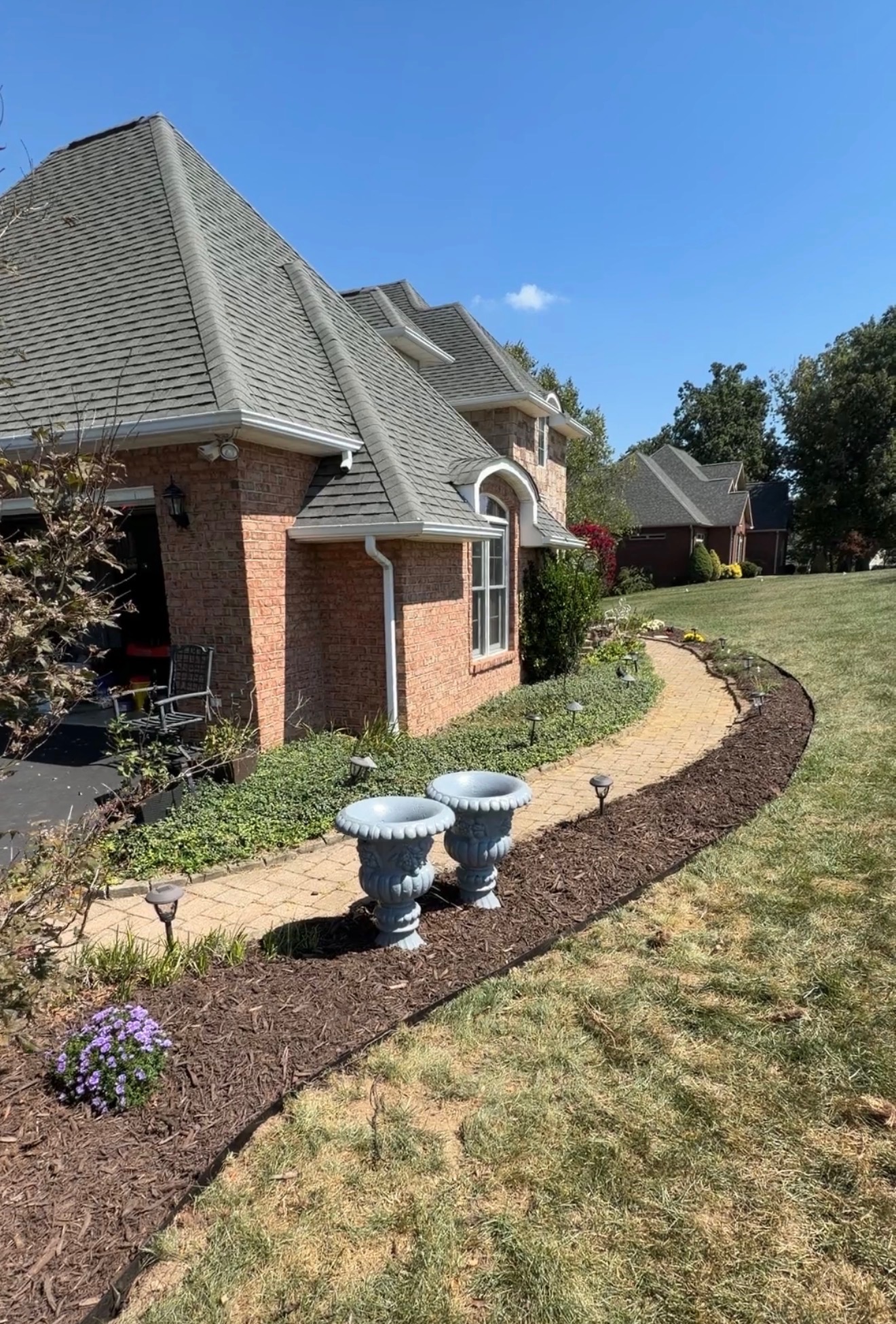 Freshly edged walkway with new mulch and plantings after The Mowgicians service